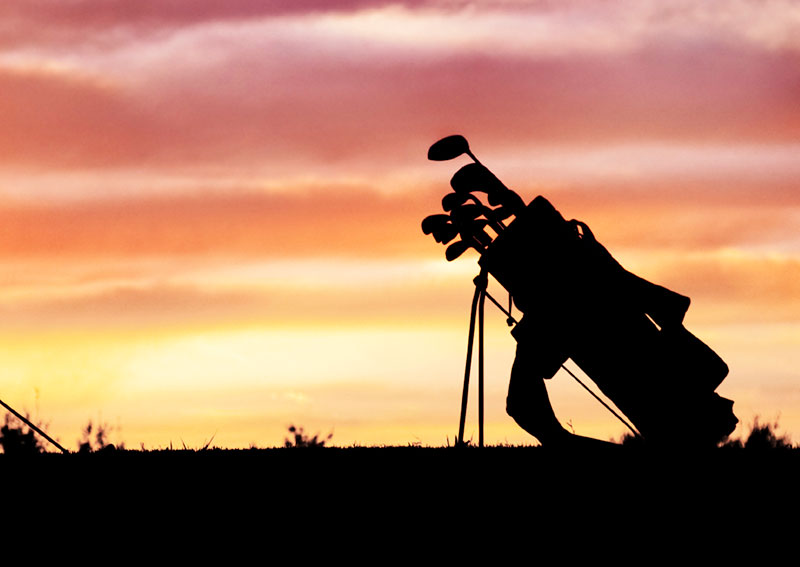 The sunset with a silhouette of golf clubs